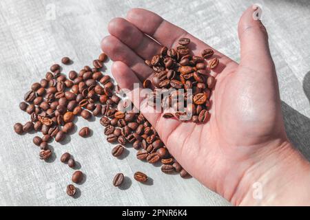 coffee beans in hand fall on the table Stock Photo