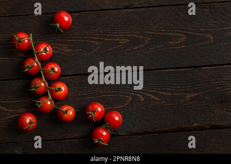 Small red cherry tomatoes on wooden table. Stock Photo