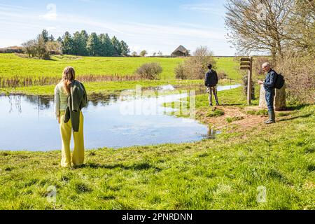 People at the start of the Thames Path at the source of the River Thames at Thames Head on the Cotswolds near Kemble, Gloucestershire UK. Stock Photo