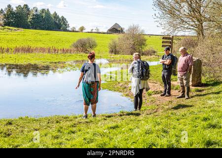 People at the start of the Thames Path at the source of the River Thames at Thames Head on the Cotswolds near Kemble, Gloucestershire UK. Stock Photo