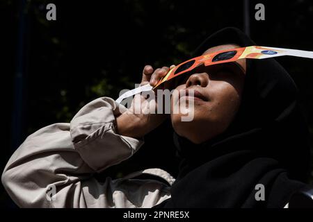 Bandung, Indonesia. 20th Apr, 2023. A Student wearing solar eclipse glasses during watch hybrid partial solar eclipse in Bandung, West Java, Indonesia, April 20, 2023. (Photo by Dimas Rachmatsyah/INA Photo Agency/Sipa USA) Credit: Sipa USA/Alamy Live News Stock Photo