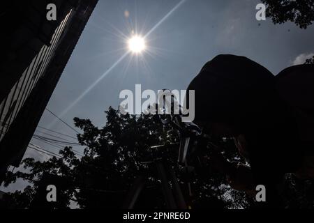Bandung, Indonesia. 20th Apr, 2023. A Student observed hybrid partial solar eclipse with telescope in Bandung, West Java, Indonesia, April 20, 2023. (Photo by Dimas Rachmatsyah/INA Photo Agency/Sipa USA) Credit: Sipa USA/Alamy Live News Stock Photo
