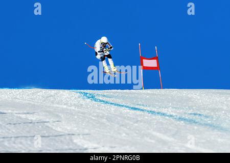 male ski racer on alpine skiing track downhill race, jump and flying on hill Stock Photo