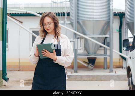 Woman Agricultural Engineer with Tablet Near Cyclone Industrial Equipment Stock Photo
