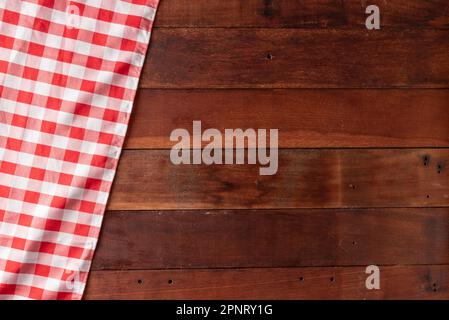 rustic wooden table background with red checkered tablecloth Stock Photo