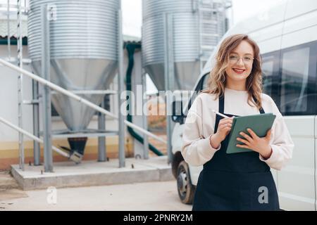 Woman Agricultural Engineer with Tablet Near Cyclone Industrial Equipment Stock Photo