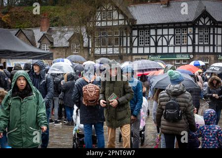 Oriental family walk along a village street under umbrellas in the rain Stock Photo
