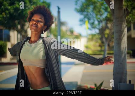 Beautiful Black woman standing on the sidewalk in Manhattan Beach, California on a summer day Stock Photo