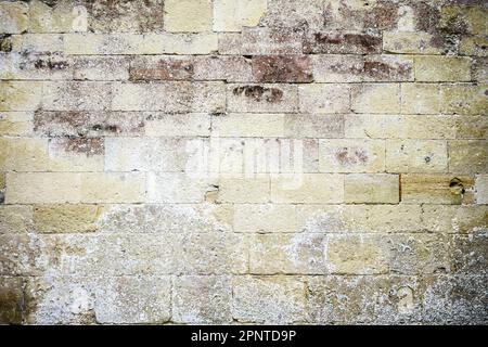 Old weathered and discoloured limestone block wall Stock Photo