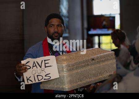 A clergy member hold signs and an empty casket inside the Tennessee Capitol chamber during a ?'Moral Monday?'? rally to address gun violence on April 17, 2023 in Nashville, Tennessee. In the wake of the March shooting at The Covenant School, in the Green Hills neighborhood of Nashville, organizations have mobilized around U.S. Rep ?Justin Jones? (?D-Nashville?), and ?U.S. Rep ?Justin J. Pearson? (??D-Memphis?)? ?who ?have drawn? ?national attention? ?pushing for gun safety laws. (Photo by Michael Nigro/Pacific Press) Stock Photo