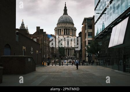 An image of St. Paul's Cathedral, London, as it appears after crossing the Millennium Bridge. People in step and the surrounding architectures. Life. Stock Photo