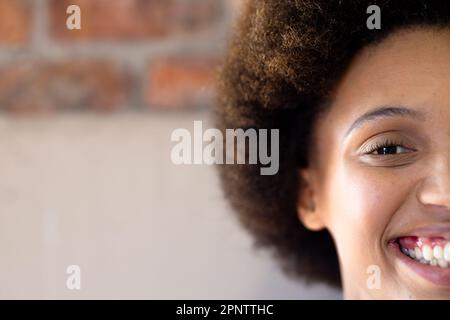 Half face portrait close up of happy biracial casual businesswoman smiling, copy space Stock Photo