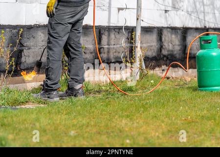 craftsman with a gas tank for a fire on a construction site Stock Photo