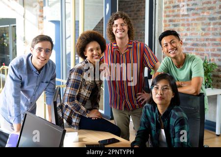 Group portrait of happy diverse creative team smiling in casual office Stock Photo