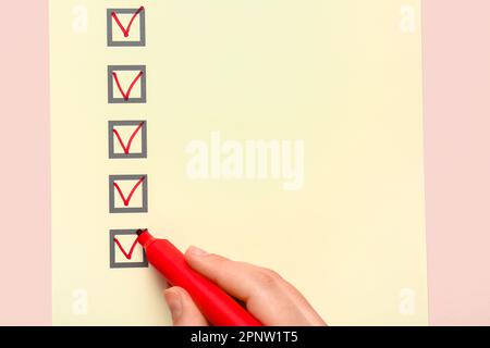 Woman marking on checklist box with red marker Stock Photo