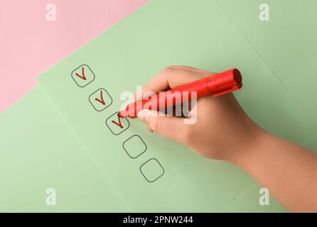 Woman marking on checklist box with red marker Stock Photo