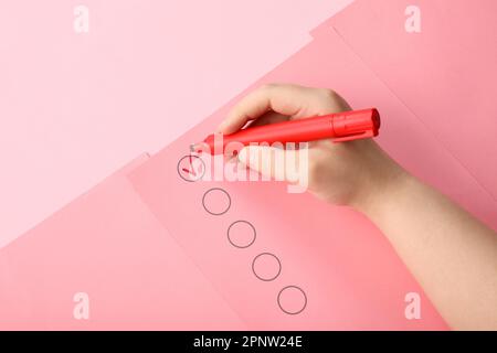 Woman marking on checklist box with red marker Stock Photo