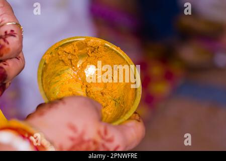 Turmeric paste in a brass bowl for Gaye holud ritual of Hindu marriage. Gatra haridra is the ceremony where haldi or turmeric is applied on bride and Stock Photo