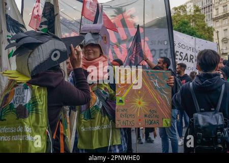Ona Concilio, center, wearing a picazuro pigeon mask, marches with members of the environmental organization Isla Verde (Green Island) to advocate for the sanction of the Ley de Humedales (Wetland Law) in Buenos Aires, Argentina on April 22, 2022. “[We are marching] in defense of the natural spaces that still enable the preservation of biodiversity,” Concilio says. (Lucila Pellettieri/Global Press Journal) Stock Photo