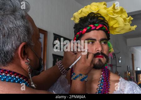 Armando Madrigal applies makeup to Bertín González, who performs as Chuntá, a traditional female character usually played by men, during Fiesta Grande in Chiapa de Corzo, Chiapas, Mexico on January 22, 2022. The festival honors the Black Christ of Esquipulas, Anthony the Great and Saint Sebastian. (Marissa Revilla/Global Press Journal) Stock Photo