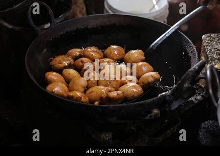 Frying kachori in a Frying Pan at a street food stall , oily food Stock Photo
