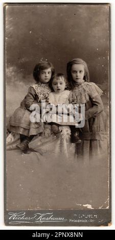 A vintage cabinet card shows cute children girls. Antique black and white photo. Stock Photo