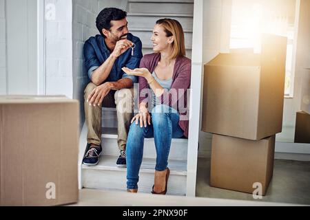 This is where our brand new story begins. a man handing his wife the keys to their new home. Stock Photo