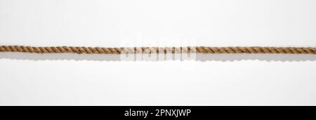Top view of long straight rope with shadow placed on white background in studio Stock Photo