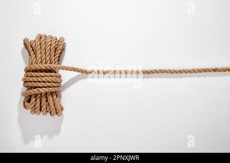 Top view of tied rope placed on white background with shadow in light studio Stock Photo