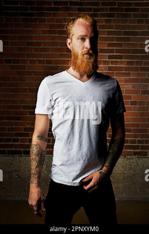Long beards, the staple of a hipster. a handsome young man in trendy attire against a brick wall. Stock Photo