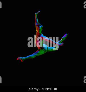 Portrait of graceful muscled male ballet dancer jumping up in air over dark studio background with neon light. Male twine Stock Photo