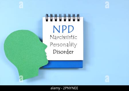 Narcissistic personality disorder or NPD diagnosis written on notepad in blue background. Flat lay composition. Stock Photo