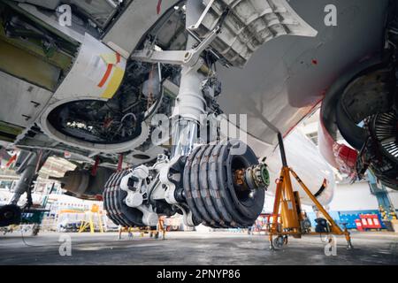 Commercial airplane under heavy maintenance. Close-up of landing gear of plane during repair. Stock Photo