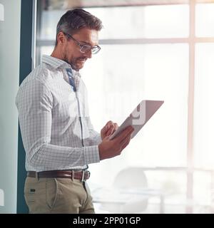 Developing new business ideas. a businessman using a digital tablet in an office. Stock Photo