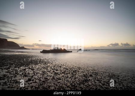 Sunset over some rocks on the beach of Lagzira. Stock Photo