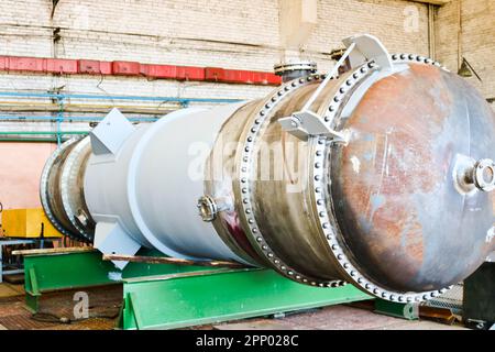 Large metal iron distillation column for separation of substances into fractions in the industrial premises of the shop at an oil refinery, chemical, Stock Photo