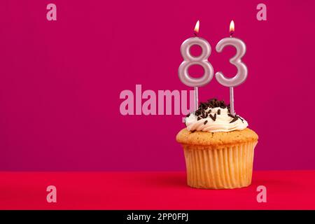 Birthday cake with candle number 83 - Rhodamine Red foamy background Stock Photo