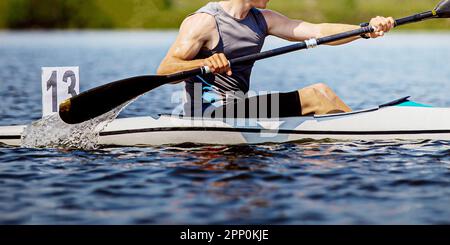 close-up kayaker athlete on kayak single in kayaking championship race, boat number 13 Stock Photo