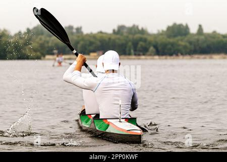 rear view two male kayakers on kayak double in kayaking competition race, sports summer games Stock Photo