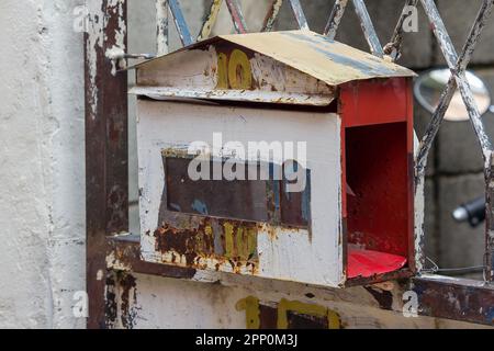 The old white mailbox was hung on the iron fence. Stock Photo