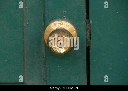 Old brass knobs on the green door Used to close or open the door Stock Photo