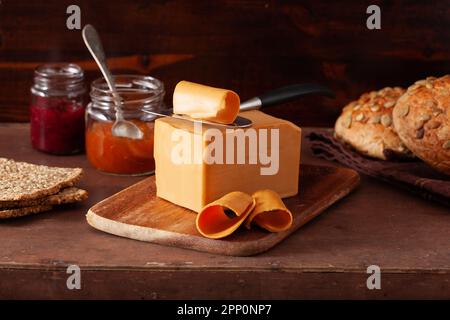 Norwegian brunost traditional brown cheese on rustic background Stock Photo