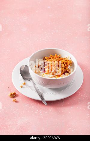 rice pudding with Norwegian brunost traditional brown cheese and raspberry jam Stock Photo