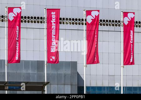 Belgrade, Serbia - March 13, 2023: Red Flags in Front of Mercator Hypermarket Store Shopping Centre Sunny Day. Stock Photo