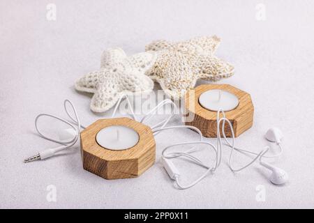 Listening to music concept. Relax, good mood. Soft accessories, candles, flat lay. Light stone concrete background, close up Stock Photo