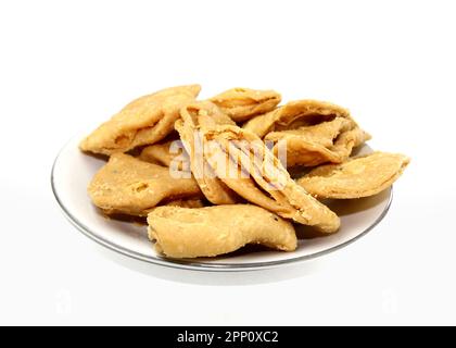 Nimki, crisp flaky flavoureds salty snack. Namak para on white background. Layered or strips Mathri or mathiya is a popular snack recipe that people e Stock Photo