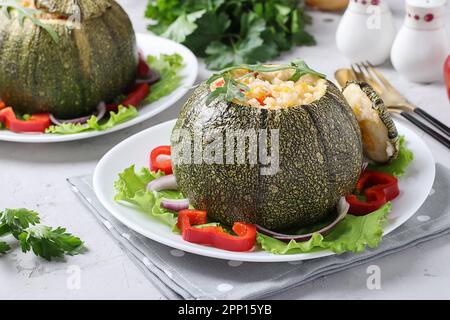 Baked zucchini stuffed with rice and vegetables on light gray background Stock Photo