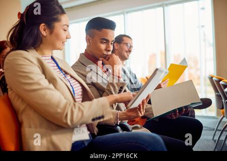 Serious multiracial corporate business team discuss paperwork at group briefing Stock Photo