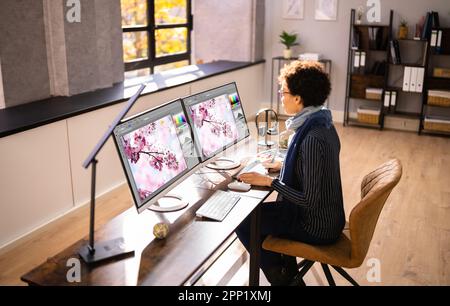 Graphic Designer Artist Working On Multiple Computer Screens Stock Photo