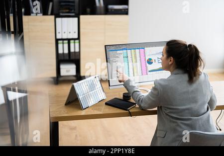 Woman Using Finance Spreadsheet Report On Laptop Screen Stock Photo
